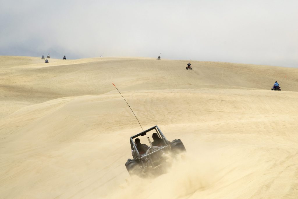 Dune Buggy Off road vehicle driving through the Oceano dunes with additional vehicles in the background